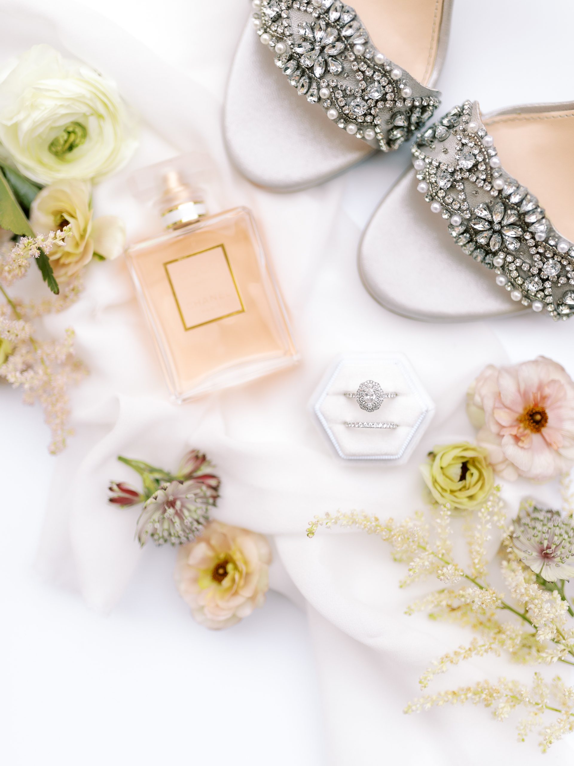 detail shot of bride wearing engagement ring and wedding shoes