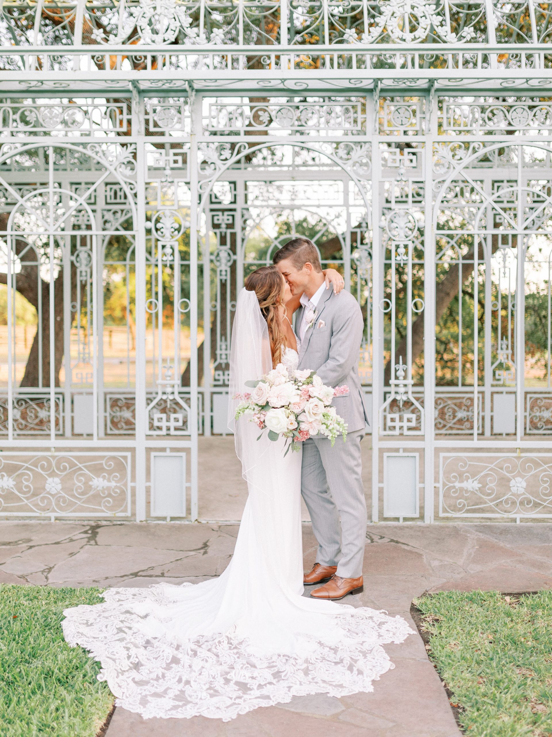Couple standing under the green cathedral at Ma Maison Austin wedding venue
