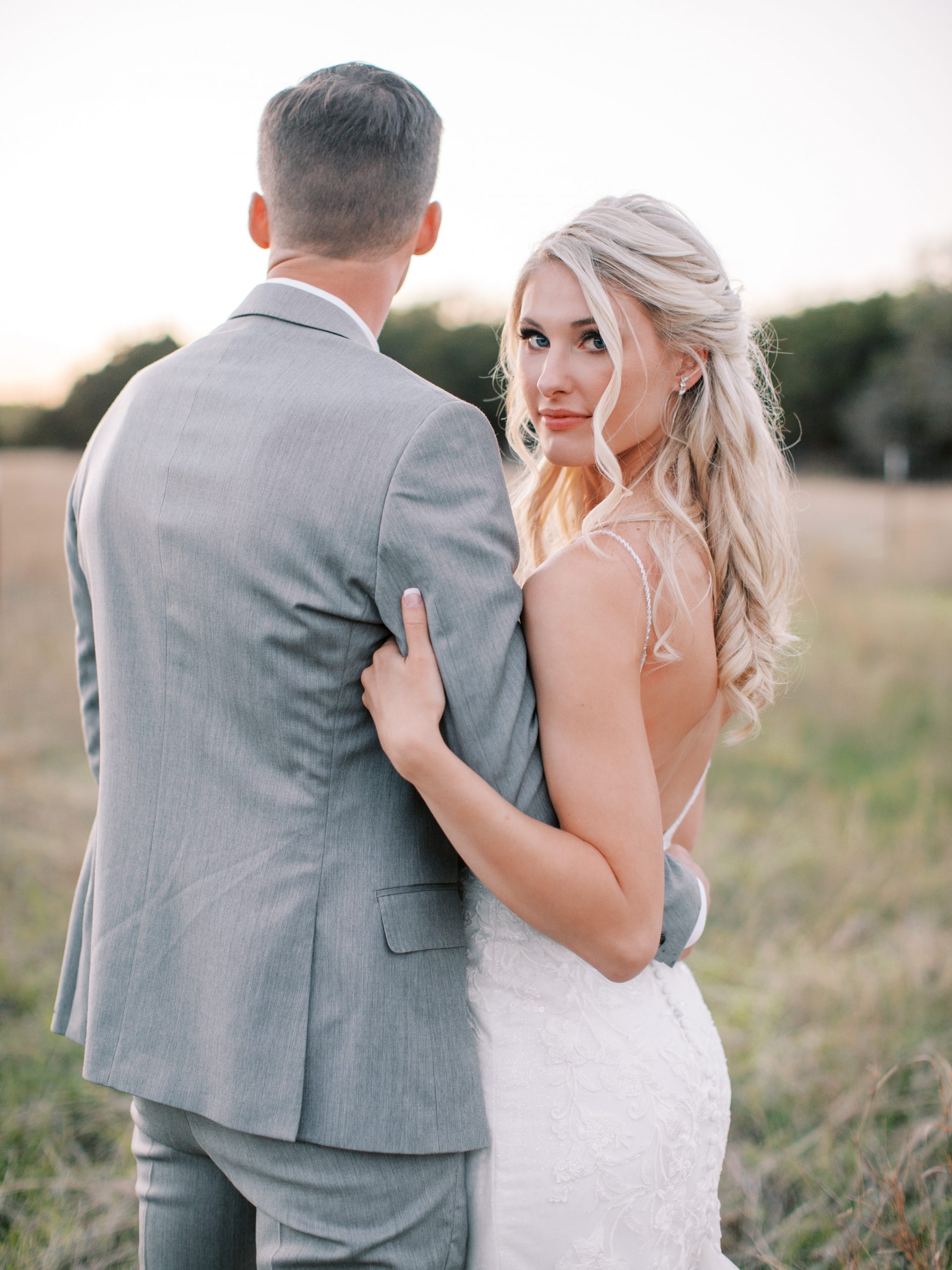 Couple standing in field at sunset at Firefly Farm Wimberley Texas wedding venues