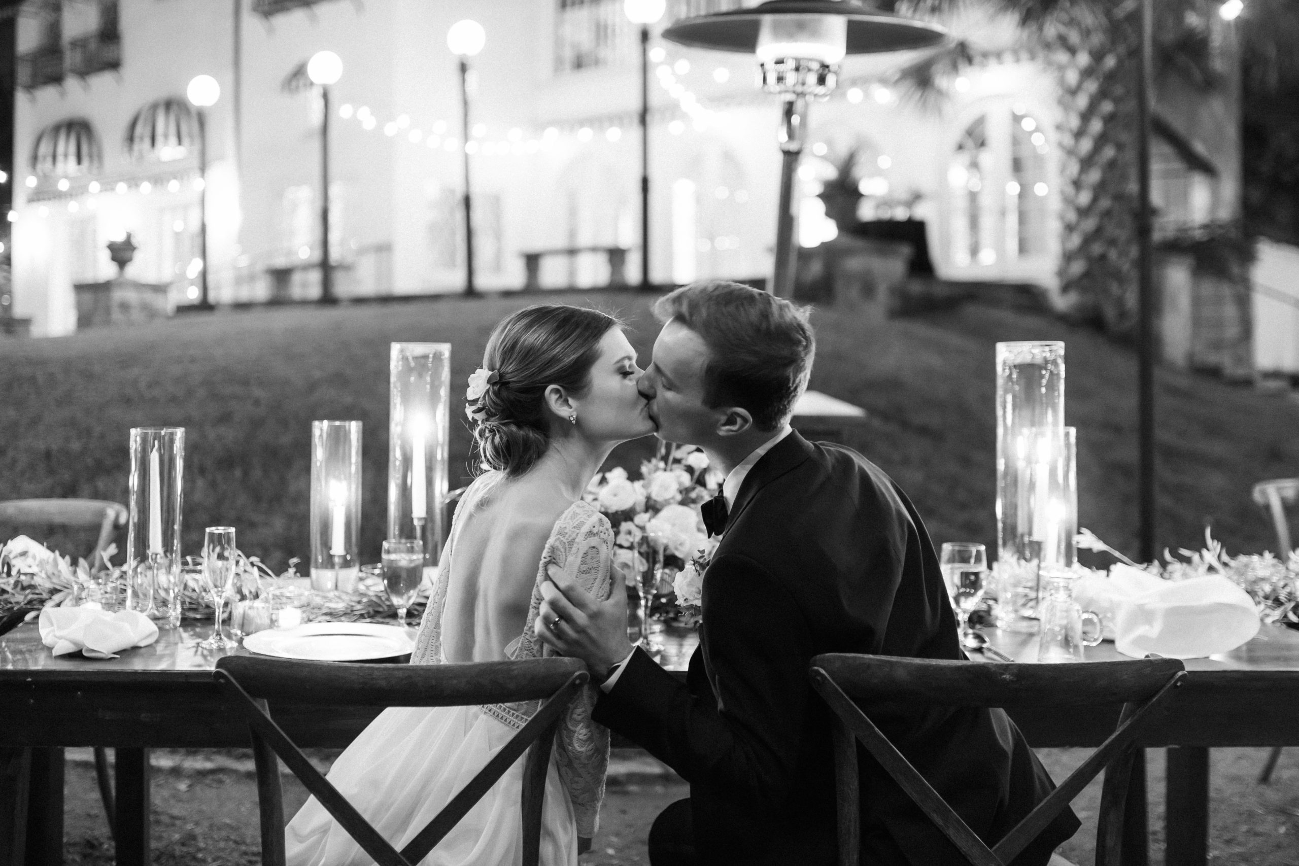 couple kissing at a candle lit dinner at laguna gloria in austin, texas